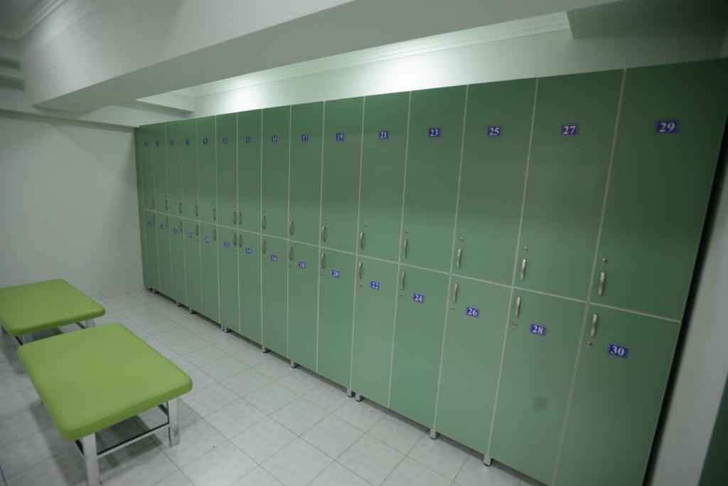 a locker room with green lockers and a green bench at City Line Boutique Hotel in Tashkent