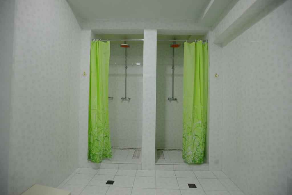 a bathroom with a shower with green shower curtains at City Line Boutique Hotel in Tashkent