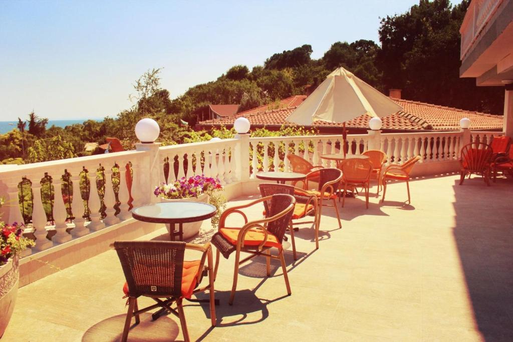 a patio with tables and chairs and a white fence at Villa Katalina in Varna City