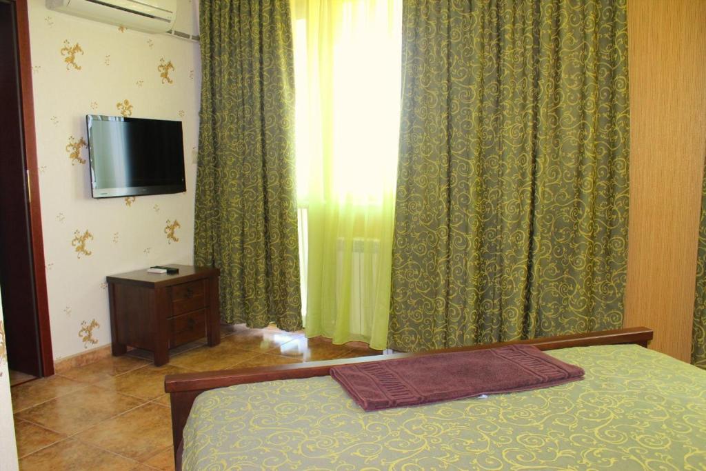 a bedroom with a bed and a television and curtains at Villa Katalina in Varna City