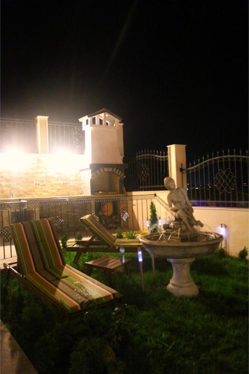a statue in a fountain in a yard at night at Villa Katalina in Varna City
