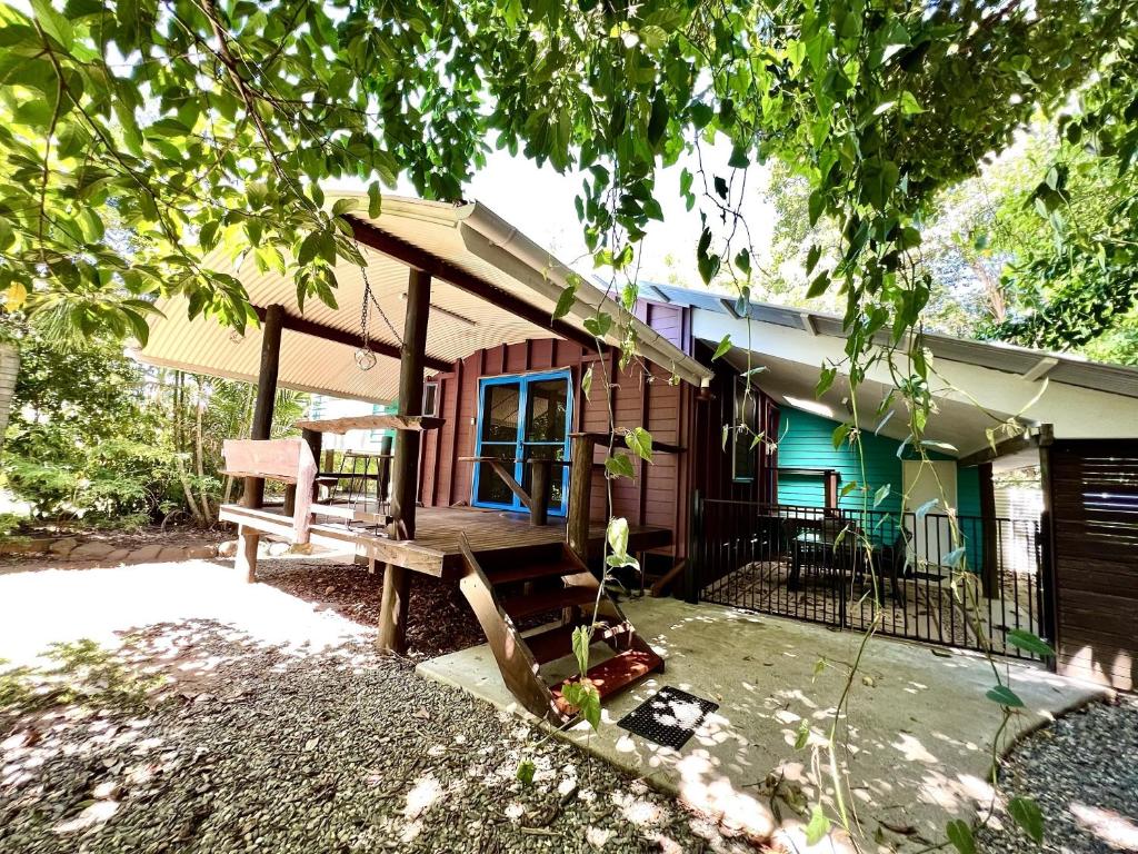 a house with a bench in front of it at Tropical Cabin Retreat in Mission Beach