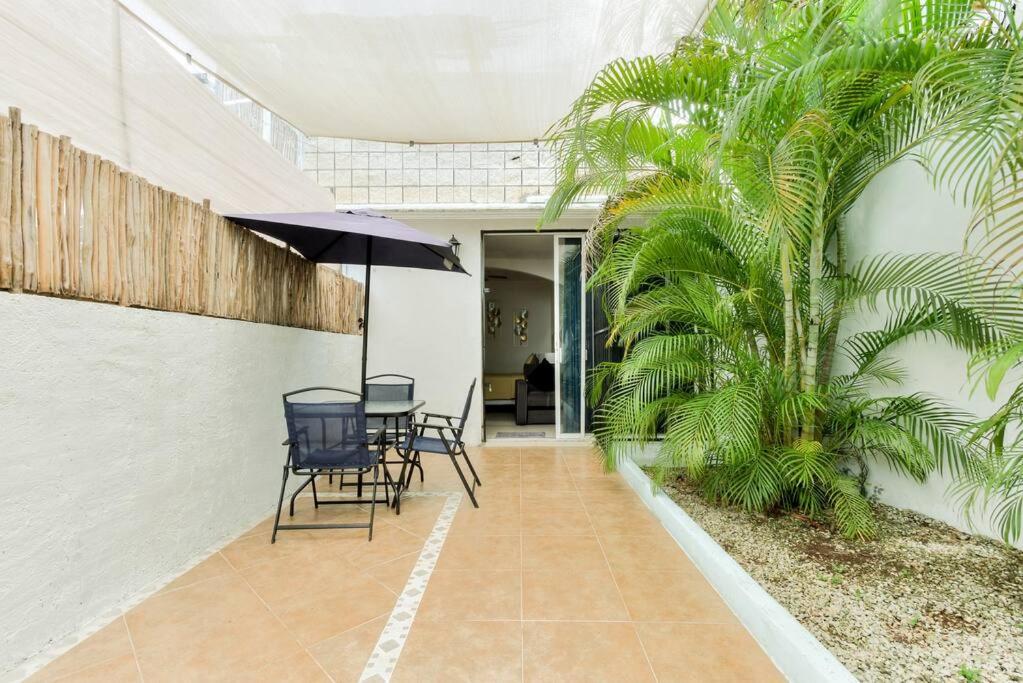 a patio with a table and chairs and an umbrella at M&Z Loft Las Palmas in Cancún