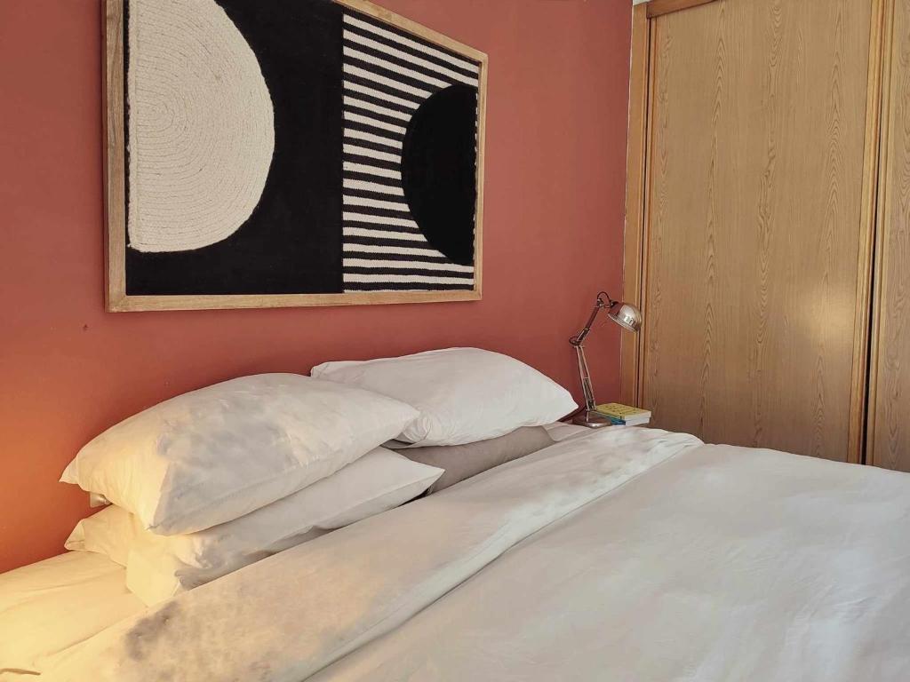 a bed with white sheets and pillows in a room at Queen Bedroom in Aljezur