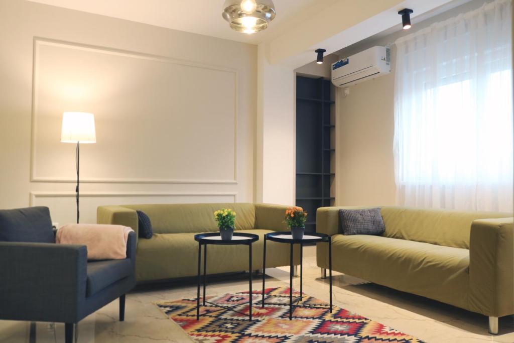 a living room with a couch and two tables at Studio Apartments in Novi Pazar