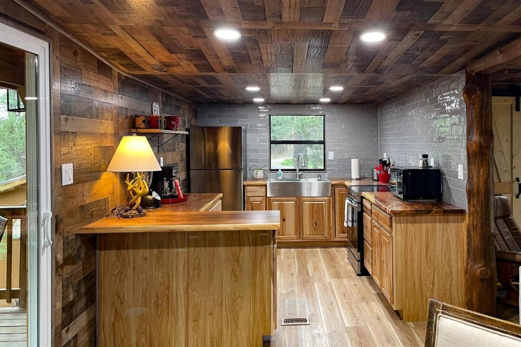 a large kitchen with wooden cabinets and a table at Great Little Cabin! in Ruidoso