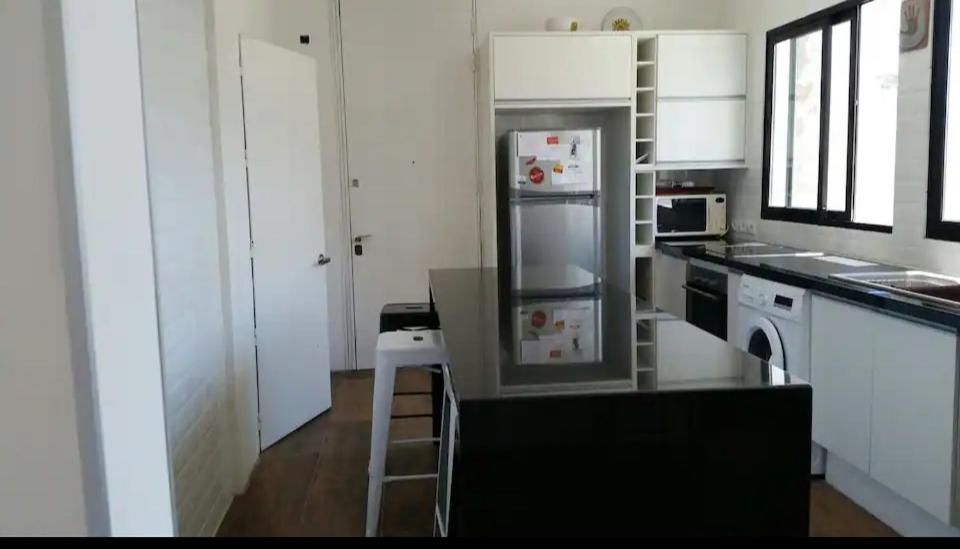 una cucina con armadi bianchi e frigorifero di Apartamento en el corazón dé Montevideo a Montevideo