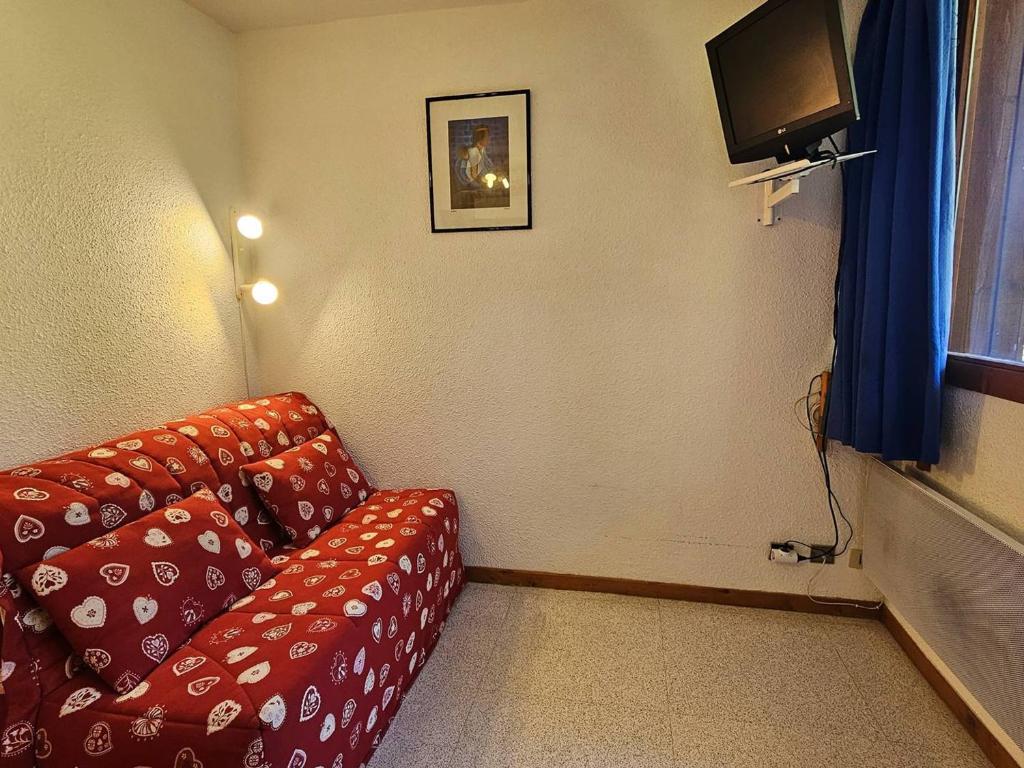 un salon avec un canapé rouge et une télévision dans l'établissement Studio pour 4 avec balcon, proche pistes, animaux admis à Vallandry - FR-1-757-119, à Landry