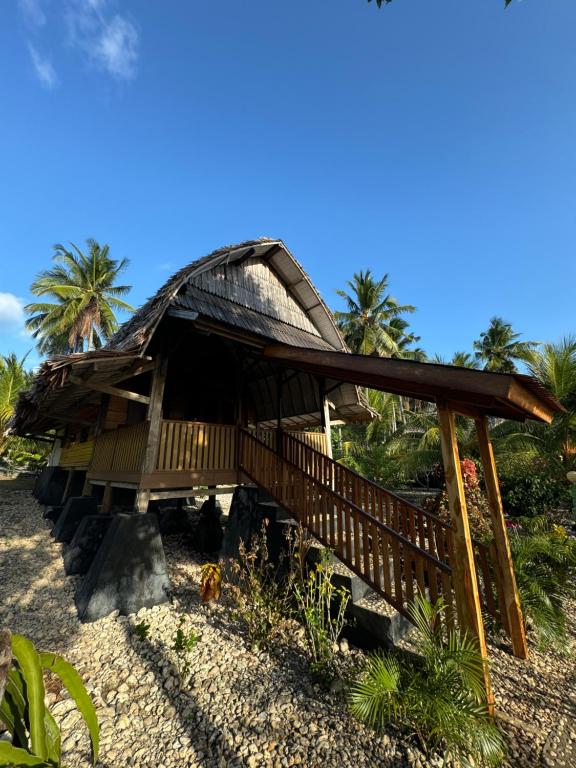 a hut with a thatched roof on a beach at Sunari Beach Resort 2 in Padang