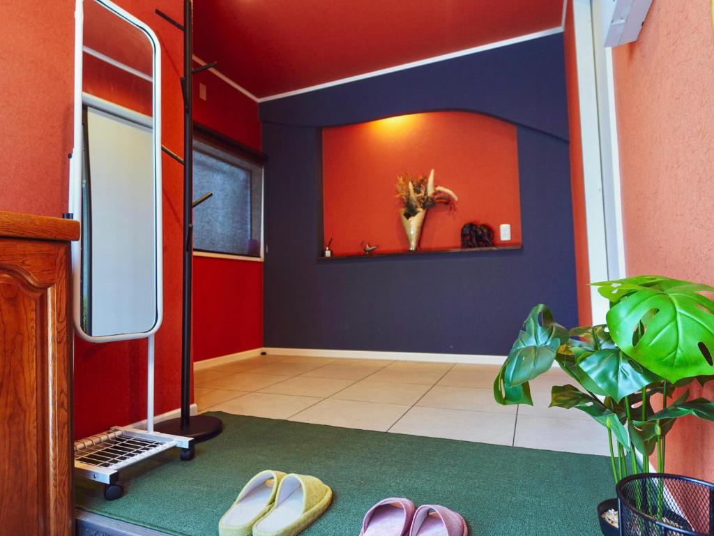 une pièce avec des murs rouges et bleus et des chaussures dans l'établissement F House 青い海, à Osaka