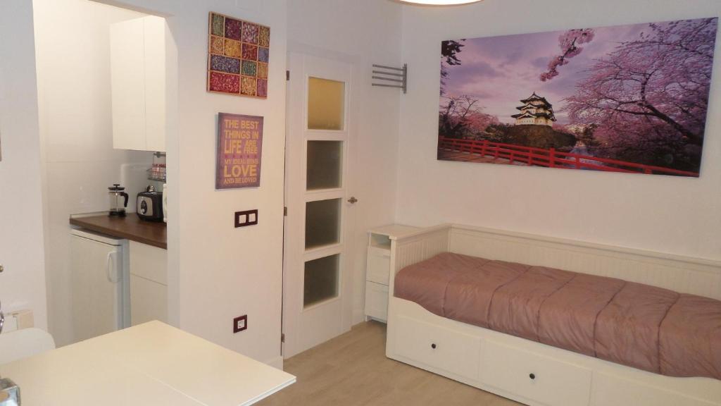 マドリードにあるApartamento Salitre 4 plazas, Centro de Madridのベッドルーム1室(ベッド1台付)が備わります。壁に絵が飾られています。