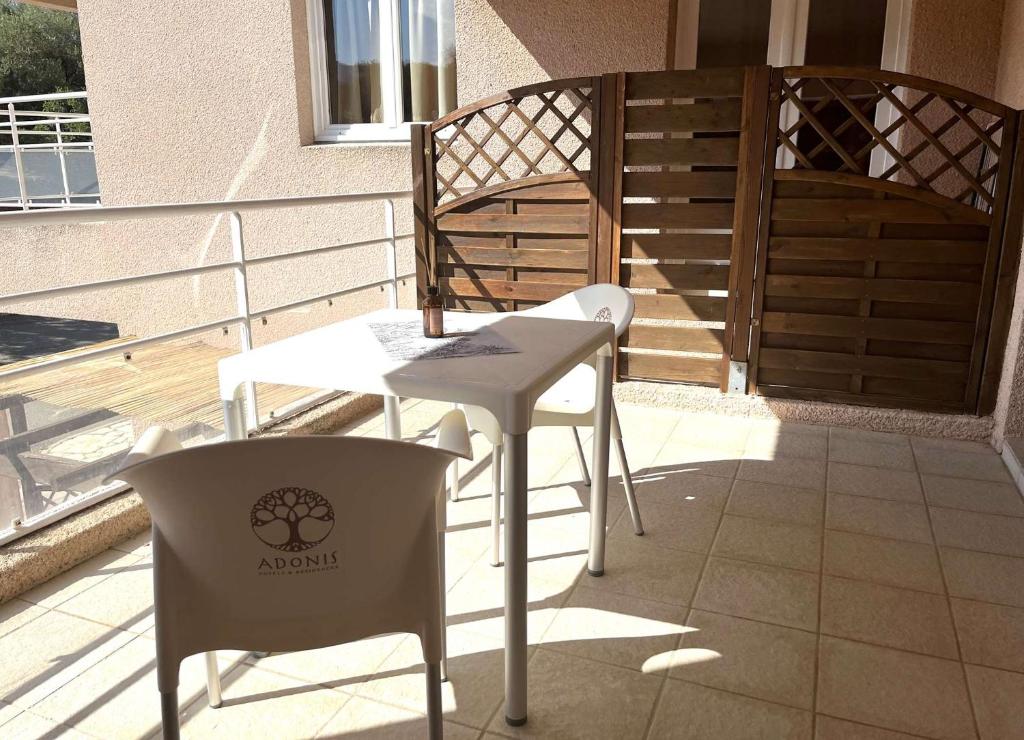 une table et deux chaises sur un balcon dans l'établissement SAINT-FLORENT Studio PISCINE FLO300-146, à Saint-Florent