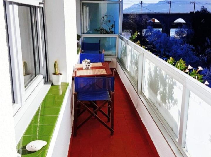 a balcony with a table and blue chairs on a balcony at Vivienda Turístico Erreka Beach in Mundaka