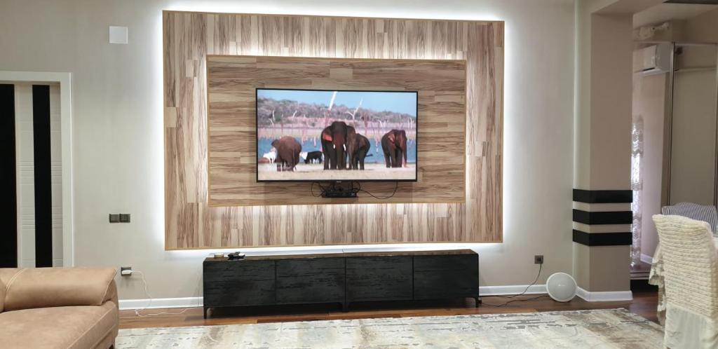 a living room with a flat screen tv on a wall at Dushanbe City in Dushanbe