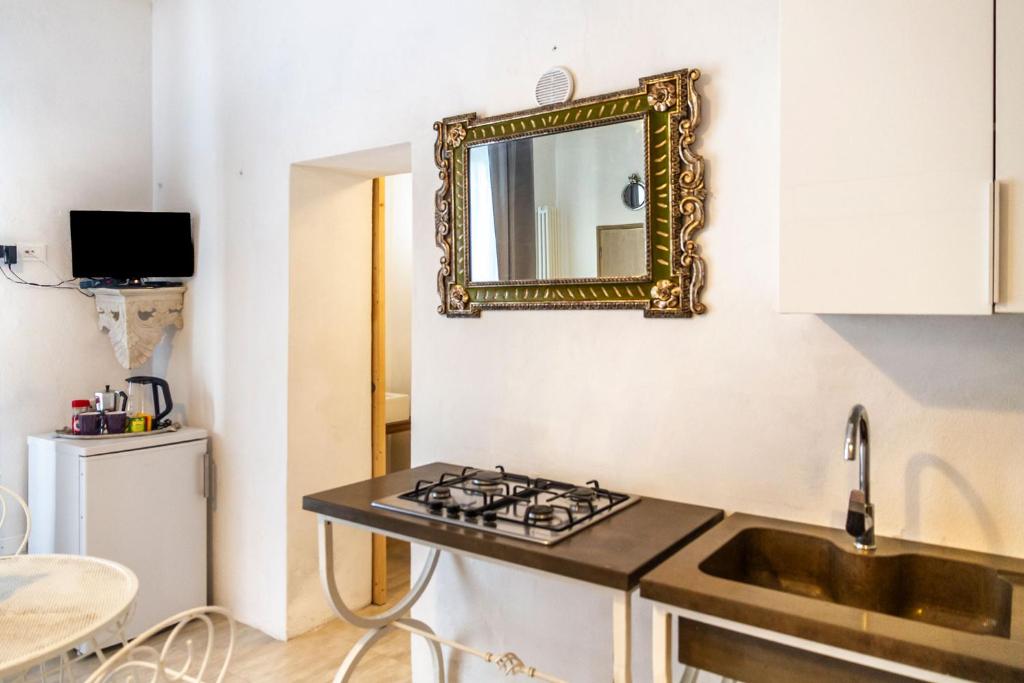 kuchnia ze zlewem i lustrem na ścianie w obiekcie Monolocale con bagno, angolo cottura e letto matrimoniale a Baldacchino w mieście Monterotondo