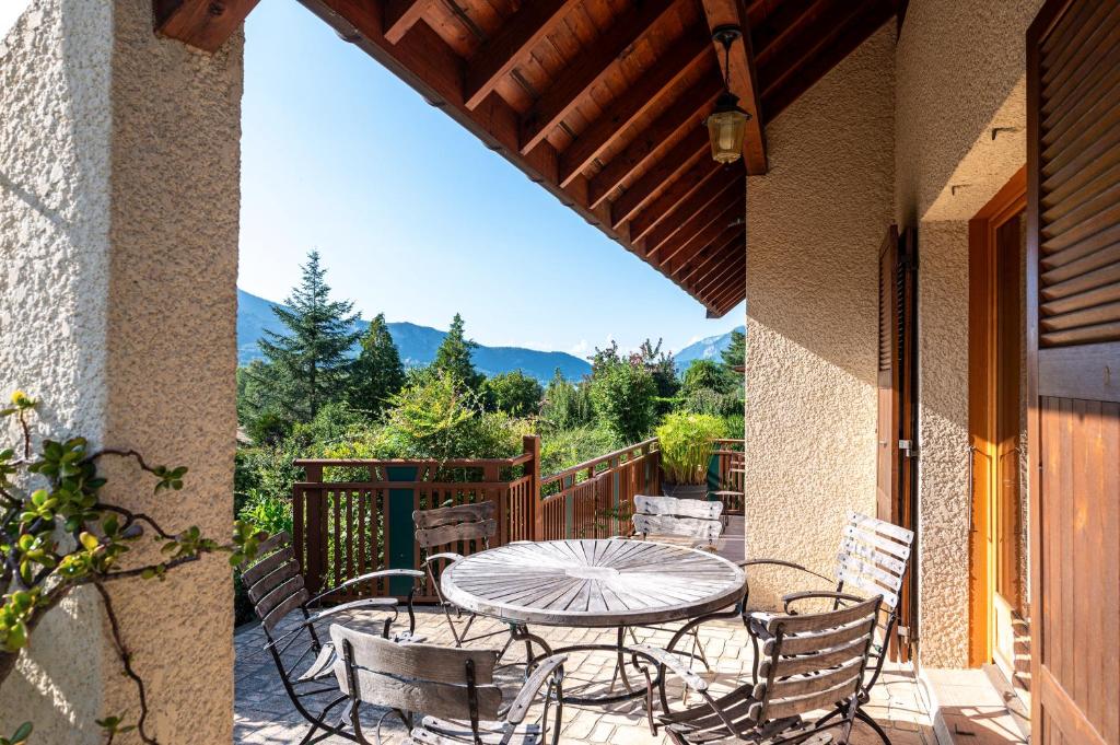 un patio avec une table et des chaises sur un balcon dans l'établissement Villa Ginkgo, à Doussard