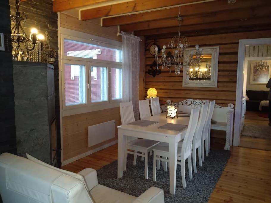 Un comedor con una mesa y sillas blancas. en Mama's house Skandinavia lake in Ivalo, en Akujärvi