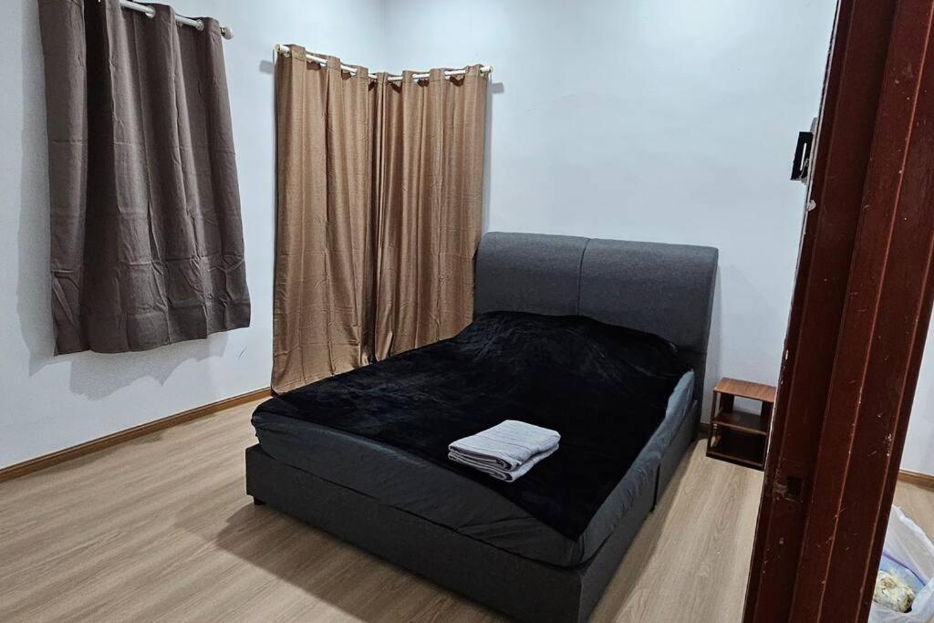 a black bed in a room with a window at Cinematic Home Stay in Ulu Choh Village