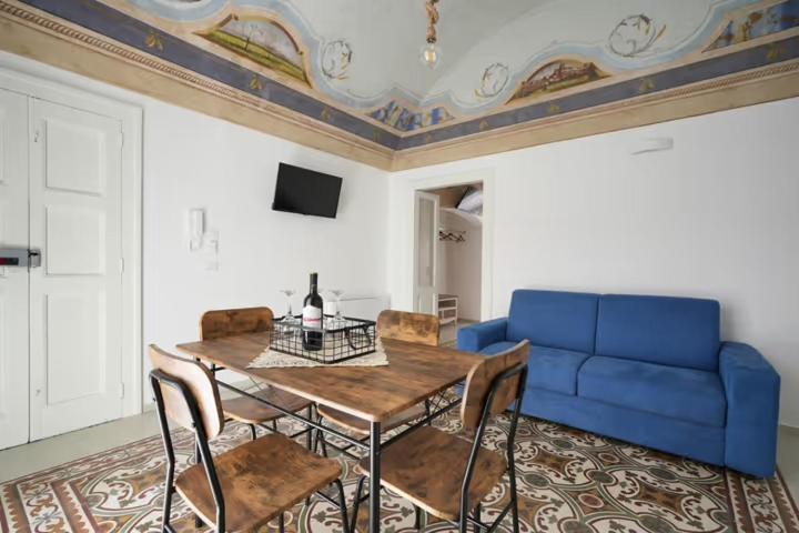 Una sala de estar con una mesa y un sofá azul. en Dimora Quarto, en Monopoli
