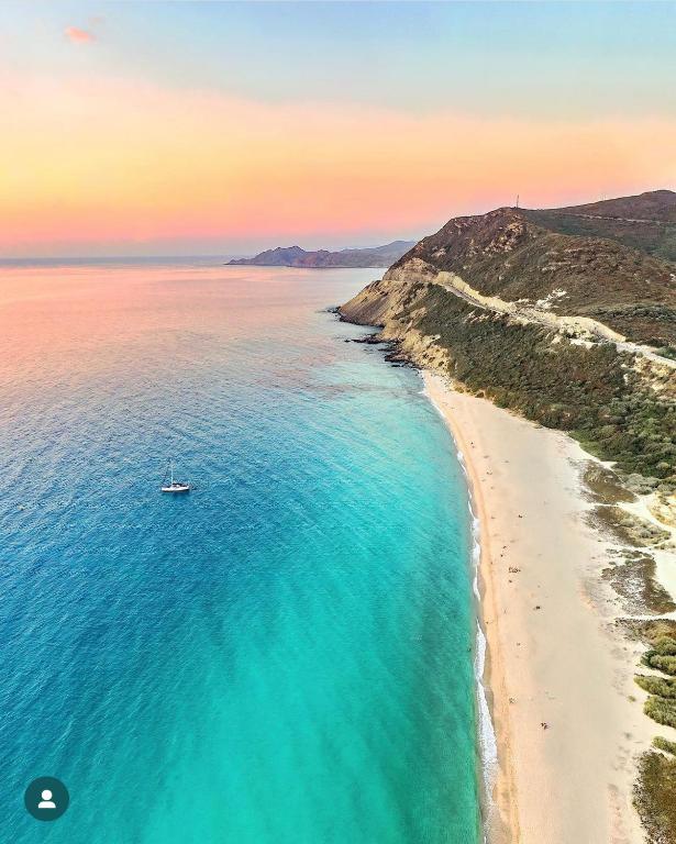 - une vue aérienne sur une plage avec un bateau dans l'eau dans l'établissement Lozarifamily, à Belgodère
