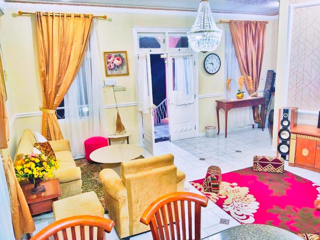 Villa Luxury kota bunga في Cikundul: غرفة معيشة مع أريكة وطاولة