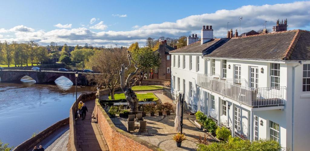 a building next to a river with a bridge at The Regency By Birch Stays in Chester