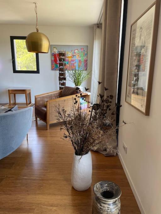 - un salon avec un canapé et un vase fleuri dans l'établissement Maison au pied du Luberon, à La Motte-dʼAigues