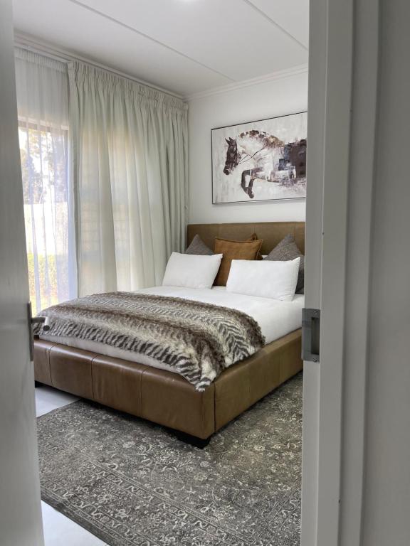 a bedroom with a large bed with a large window at ventura 250 in Sandton