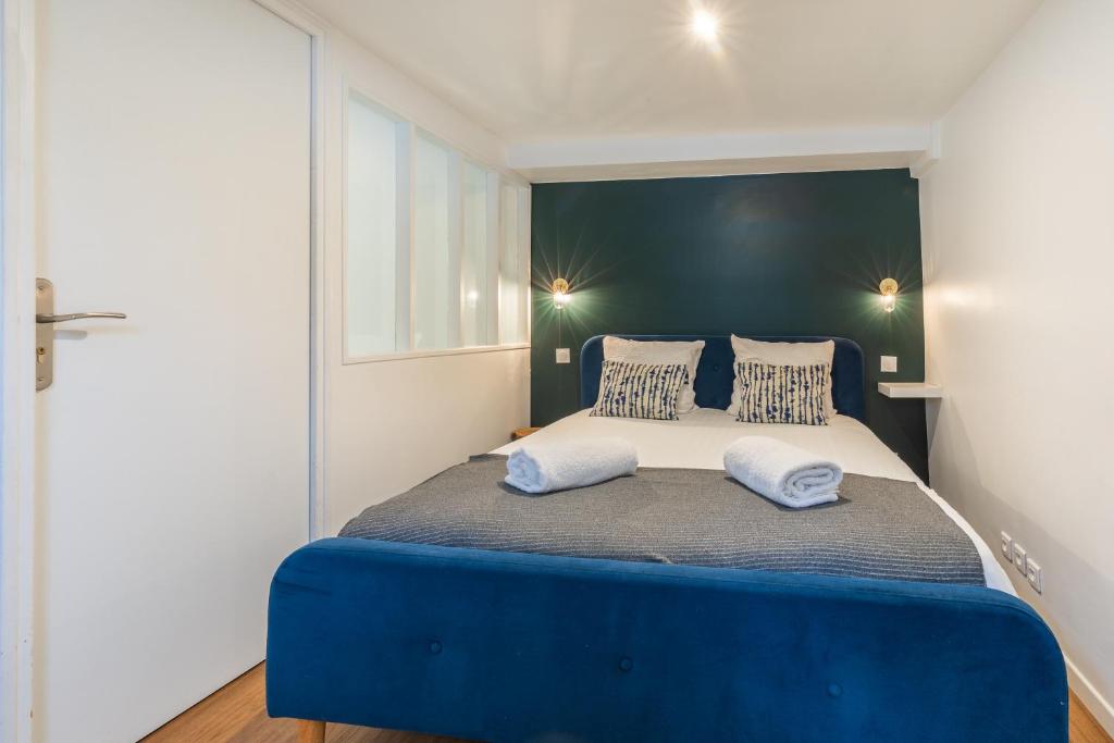 - une chambre dotée d'un lit bleu et blanc avec deux oreillers dans l'établissement SENTIER, MARAIS, spacieux duplex 2 salles de bain, à Paris