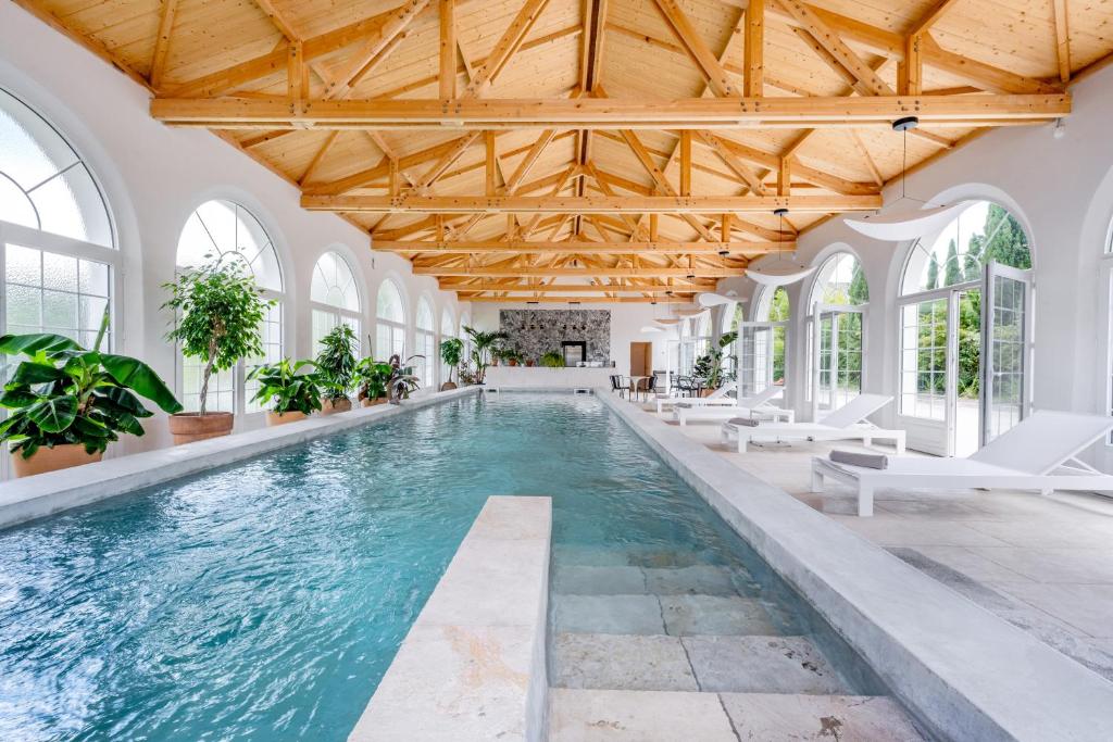 an indoor pool with a wooden ceiling and windows at Secret d'Uzès - Le Loft - Avec piscine chauffée in Uzès