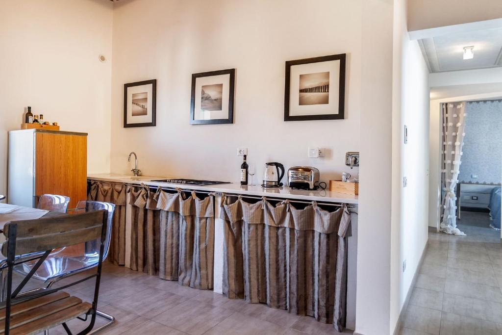 a kitchen with a counter with curtains on it at Ampio appartamento di Charme con 2 camere, 2 bagni, terrazza, aria condizionata, in posizione Centralissima in Cecina