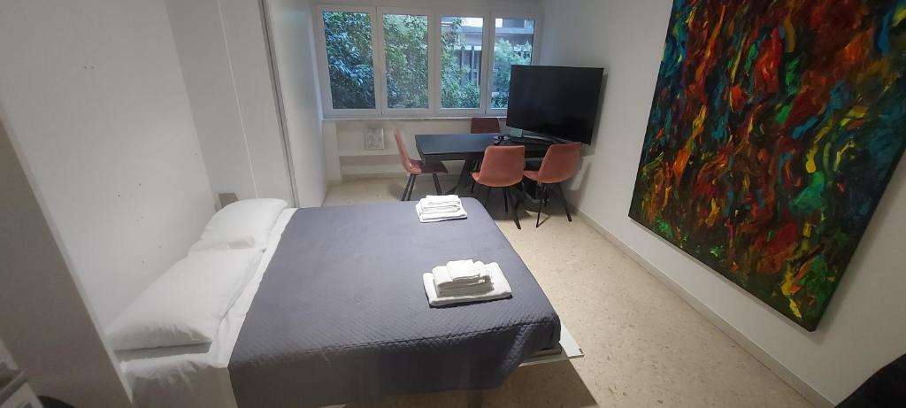 a room with a bed and a table and a painting at La Casa dell'Architetto in Bari