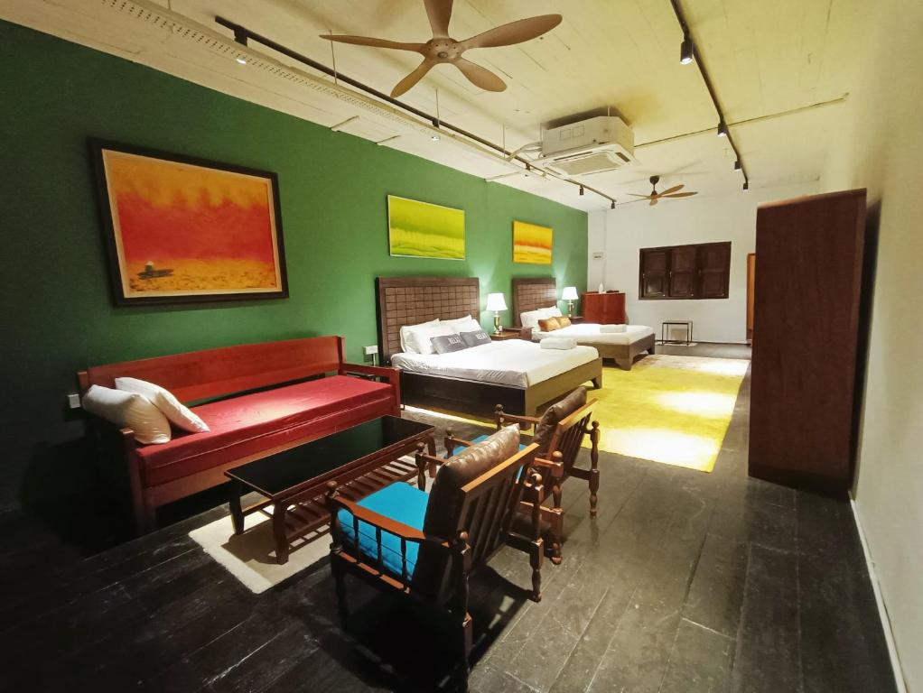 un soggiorno con un divano e un letto di 57 Ruma Oren Heritage Jonker Residence Melaka a Malacca