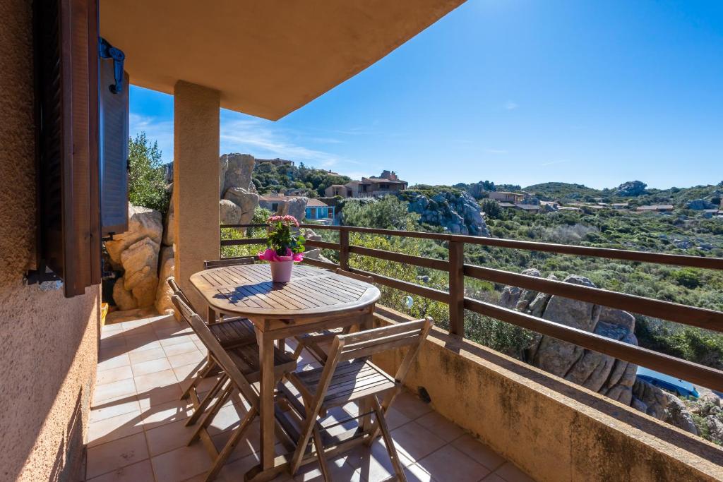a patio with a table and chairs on a balcony at Villetta Panoramica Costa Paradiso in Costa Paradiso