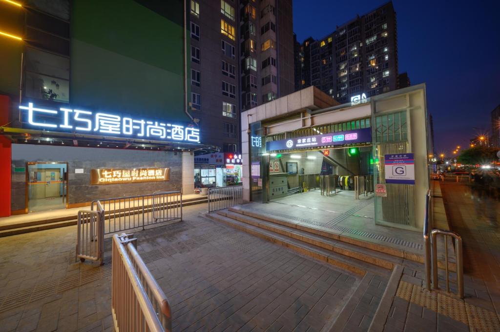 an empty sidewalk in a city at night at QiQiaoWu Fashion Hotel - Beijing Songjiazhuang Subway Station in Beijing