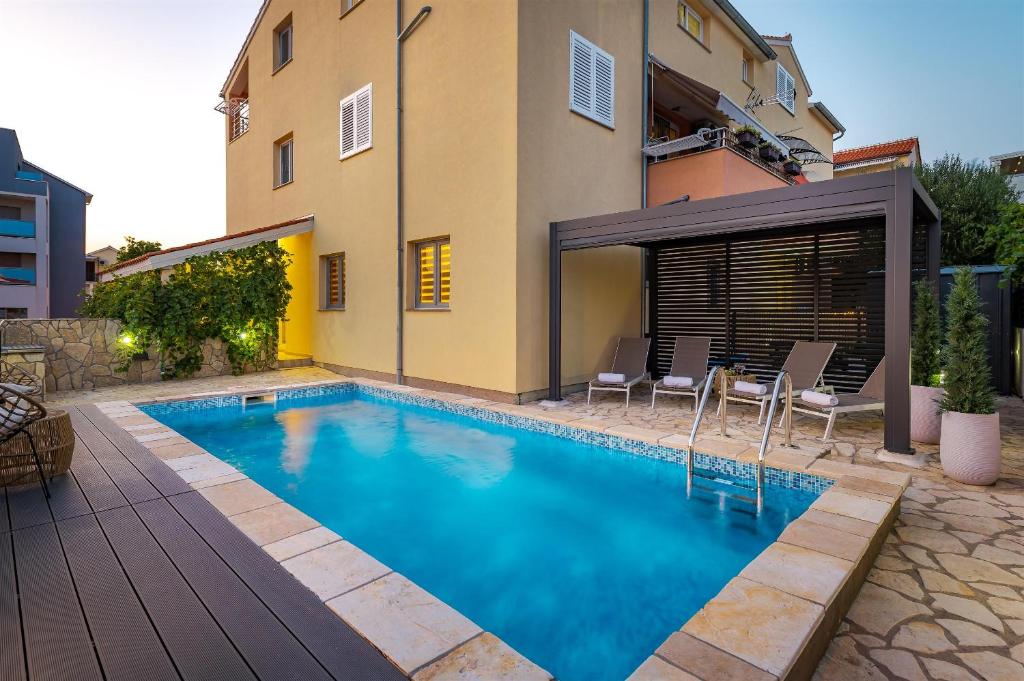 een zwembad voor een huis bij Apartment Dora family only in Vodice