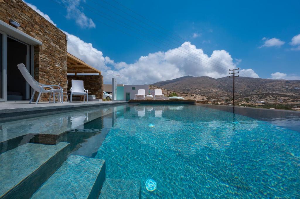 a swimming pool with a view of the mountains at Calma Ios in Ios Chora