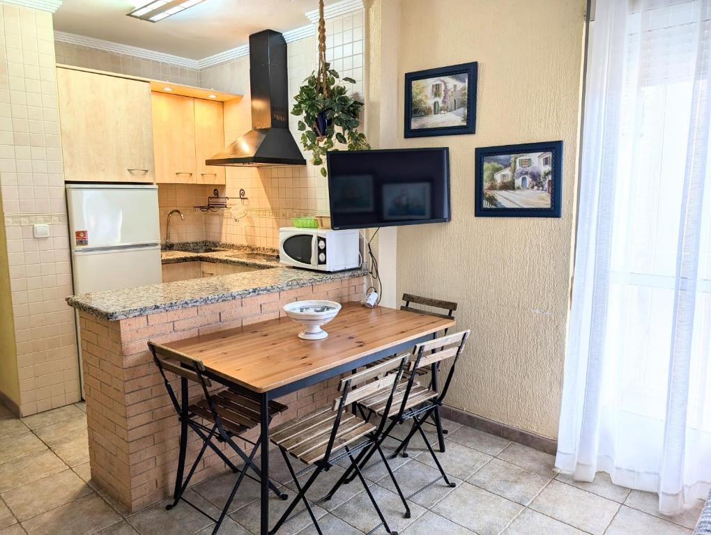 a kitchen with a wooden table and some chairs at IslaOC Apartamentos - Apartamento con Acceso Privado a Playa in Isla Cristina