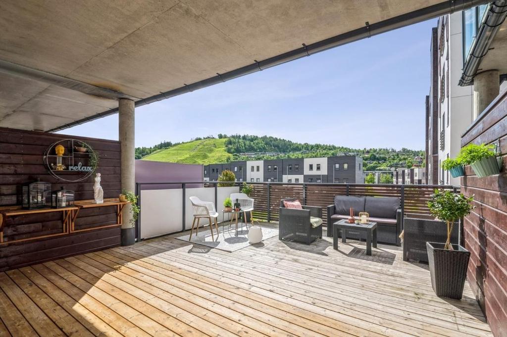 an outdoor deck with chairs and tables on a building at child friendly 4 room apartment in Kolsås