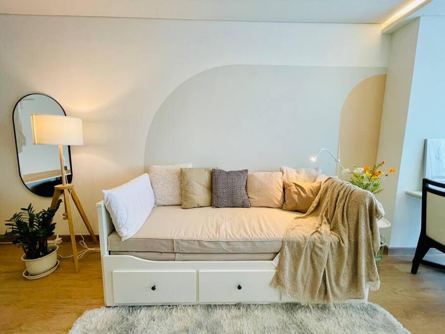 - un canapé blanc dans une chambre avec un miroir dans l'établissement Cozy Spacious 55sqm 1BR 200m BTS PhraKhanong, 10min Thonglo, à Bangkok