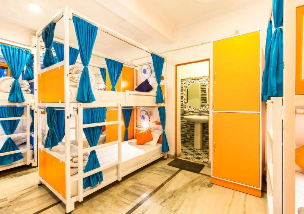 a bedroom with bunk beds with yellow and blue at ZoukStayz in Rishīkesh