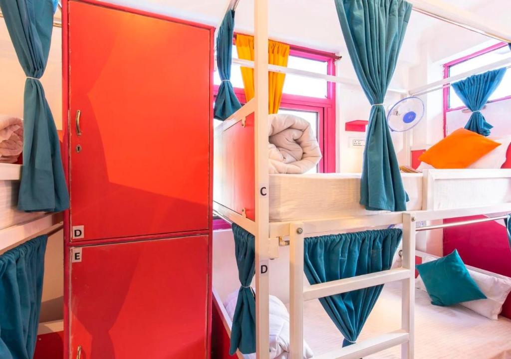 a room with bunk beds and a red door at ZoukStayz in Rishīkesh