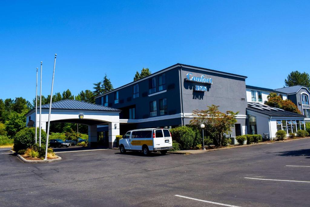 a building with a car parked in a parking lot at Comfort Inn Bellingham in Bellingham