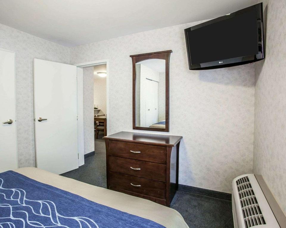 a bedroom with a bed and a dresser with a mirror at Comfort Inn Bellingham in Bellingham