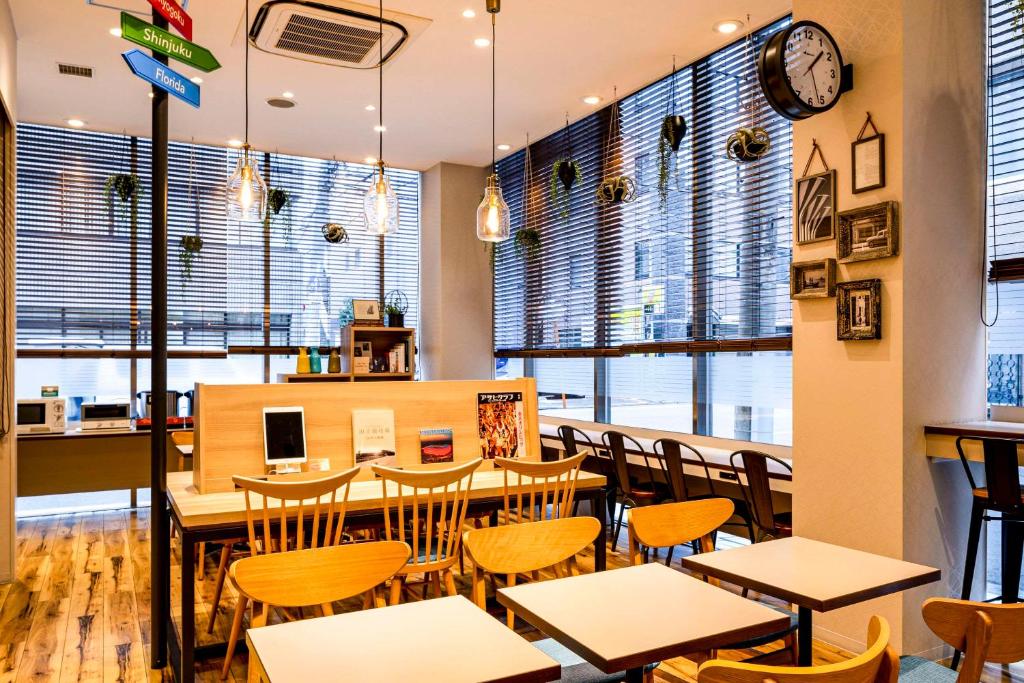 a restaurant with tables and chairs and windows at Comfort Hotel Tokyo Kanda in Tokyo
