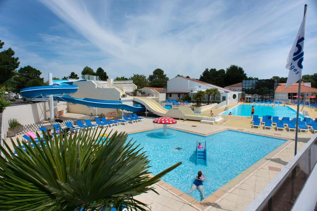 een zwembad in een resort met een glijbaan bij Camping Officiel Siblu Le Bois Masson in Saint-Jean-de-Monts