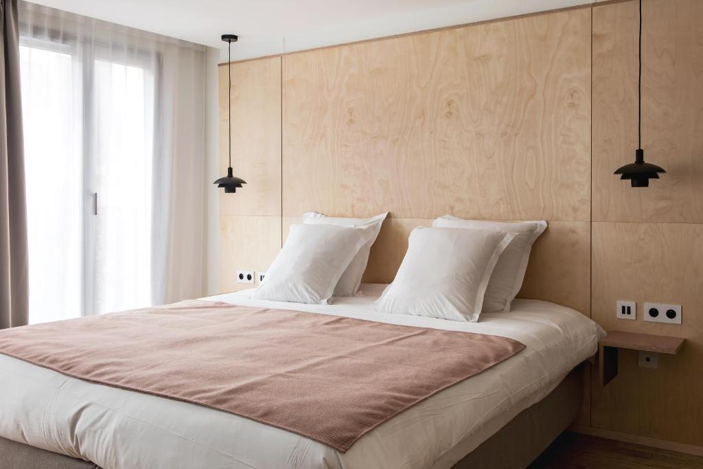 a bedroom with a large bed with white pillows at New Hotel Opéra in Paris