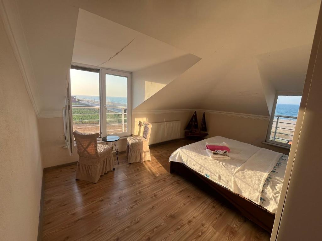 a bedroom with a bed and two windows at Airport See Viem Apartment in Arnavutköy