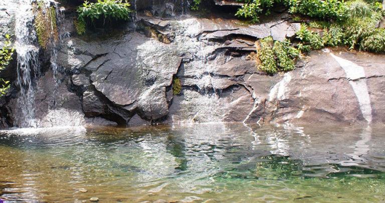a waterfall next to a body of water at Maison Capanelli in Casa delle Torre