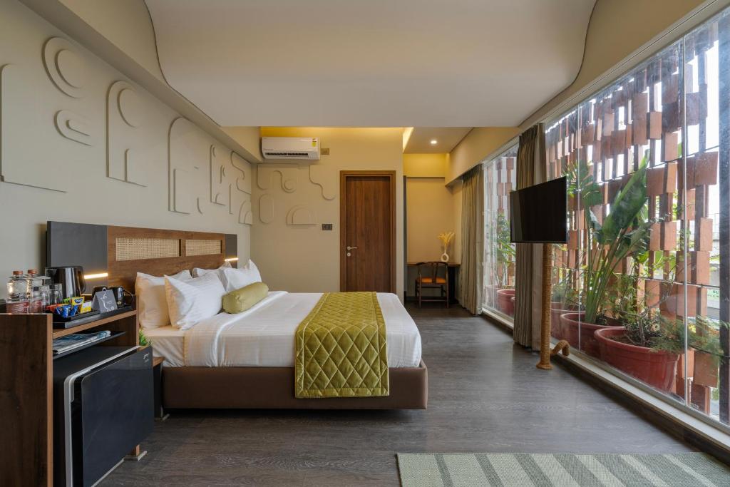 a hotel room with a bed and a large window at Fressotel, Kanakapura Road in Bengaluru